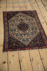 High-angle view of a vintage Senneh rug mat with its navy hexagonal medallion and ivory field.