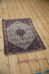 A high-angle view of the vintage Senneh rug, showing the navy and ivory hexagonal medallion.