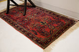 Intricate navy blue border and restored creamy fringe on a vintage Sarouk rug.