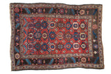 Antique Kurdish Bijar rug with a triple column design of stylized floral medallions in gem-tone red, sapphire blue, and charcoal.