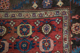 Corner detail of a collector's Kurdish Bijar rug with a serrated leaf border and floral motifs.