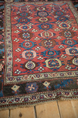 The geometric floral field and dark serrated leaf border of a collector Kurdish Bijar rug.