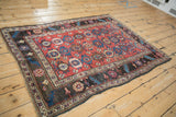 Angled perspective of an antique Kurdish Bijar rug displaying its triple column floral pattern.