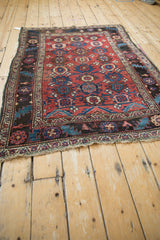 Angled perspective view of the entire antique Kurdish Bijar rug, showing its traditional column design.