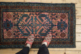 Hand-knotted Mehriban rug with ram's horn vines and geometric floral motifs on dusty raspberry.