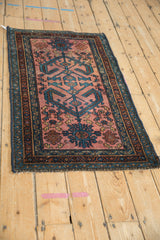Persian Mehriban rug's geometric dusty raspberry field with sapphire blue ram's horn motifs.