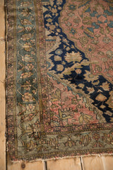 Antique Malayer rug corner, intricate floral field in dusty blush with ornate teal borders.
