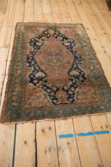 Fine weave of Malayer rug corner, showing dusty slate blue floral border, frayed fringe.