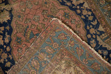 Antique Malayer rug corner showing folded dusty blush, navy pile, pale blue reverse, tattered fringe.