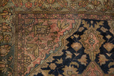 Fine weave and intricate motifs on a Persian Malayer rug corner in navy and dusty blush tones.