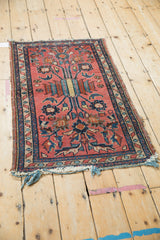 Detail of vintage Mehriban rug, pale raspberry field, layered floral stems, navy serpent border.
