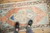 Vintage distressed Oushak runner with faded terracotta, denim, and mint green patterns.