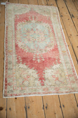 Distressed pile texture of raspberry red and powder blue vintage Oushak rug border and field.