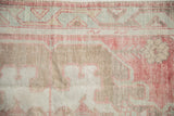 Worn hand-knotted texture of a vintage Oushak rug in dusty cherry red, coffee brown, and muted slate blue.