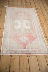 Distressed Oushak runner with a time-softened patina over its red and pale blue geometric design.