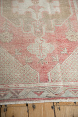 Low, worn pile showing the corner spandrel's lattice detail in dusty red and pale coffee brown.
