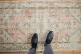 Distressed Oushak runner with even wear and faded dusty rose and turquoise patterns.