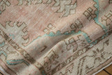 Distressed vintage Oushak rug runner with even wear, showing faded dusty rose and pale turquoise pile.