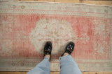 A scale view of the distressed Oushak rug runner's soft blush and seafoam texture.