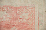 Close-up of the low knot heads and blush corner spandrels on a distressed Oushak runner.