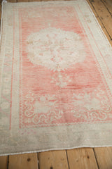Lengthwise perspective of a distressed Oushak runner showing its soft blush and silver palette.
