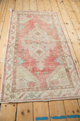 Distressed vintage Oushak runner, showing faded cherry red field, pale palmettes, and geometric border.