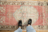 Worn medallion and time-softened texture of a distressed Oushak runner in blush and beige.