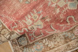 The distressed, low pile of a vintage Oushak runner in blush pink and dusty blue.