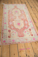 Vintage Oushak runner's distressed texture, pinwheel blossom border with magenta and pale slate blue.
