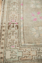 Geometric brown border of distressed vintage Oushak rug, with pale blue and soft pink.