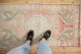 A distressed vintage Oushak rug's faded blush and silver pattern shown in a top-down lifestyle view.