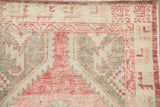 Close-up showing the even, low-pile wear on the geometric corner of a distressed Oushak rug.