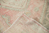 Reverse weave and low, worn pile of a vintage hand-knotted Turkish Oushak rug.