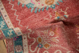 Distressed vintage Oushak rug showing folded pile texture with raspberry red and turquoise tones.
