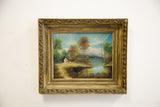 Ornate gold frame and painted scene of lake, blue sky, and autumn trees.