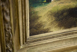 Close-up of the vintage oil painting's indistinct signature and ornate gold frame.