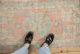 Vintage distressed Oushak rug with dusty rose, mint green traditional curvilinear pattern, mostly even wear.