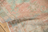 Vintage distressed Oushak rug with softened texture and muted rose, mint, and blue.