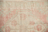 Distressed Oushak rug texture with hand-knotted pile, soft blush and sand motifs.