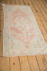 Distressed left selvage and muted floral pattern of a vintage Oushak runner.