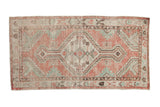 Vintage distressed Oushak runner with a geometric medallion in dusty rose, sea foam green and brown.