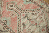 Close-up of the distressed Oushak rug's weave, showing even wear on the dusty rose and mint green geometric motifs.