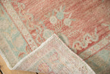 Distressed vintage Oushak runner, dusty rose pile with mint motifs, revealing hand-knotted foundation.