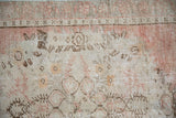 Decorative distressed Oushak rug: faded rose, ivory, and brown curvilinear motifs.