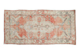 Vintage distressed Oushak rug runner with a geometric medallion in faded cherry red, silver, and pale turquoise.