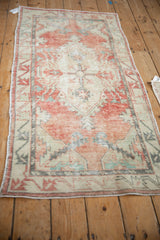 Angled view of a distressed Turkish Oushak runner showcasing its decorative wear and muted colors.