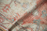 Softly worn pile of a vintage Oushak rug with cherry red, silver, and turquoise details.