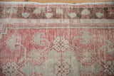 Worn texture on the stepped corner spandrel and blossom border of a vintage Oushak rug.