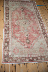 Angled perspective of a vintage Oushak runner, highlighting its low-pile texture and faded colors.