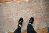 Low-pile texture of a distressed Oushak rug runner in dusty rose and antique ivory tones.